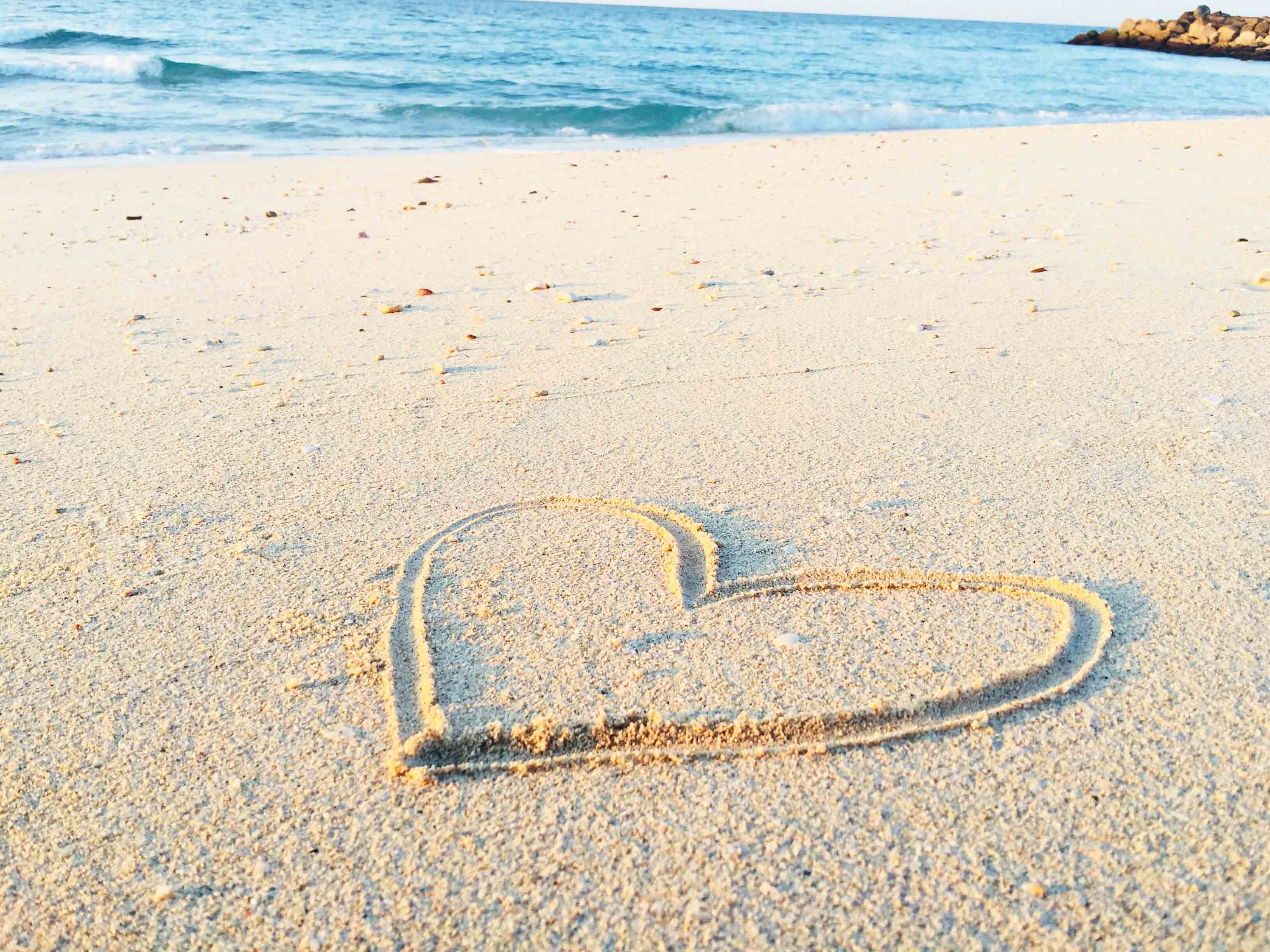 sandy beach with heart drawned in sand